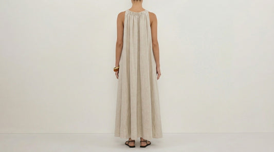 Person wearing a long beige dress on a white background