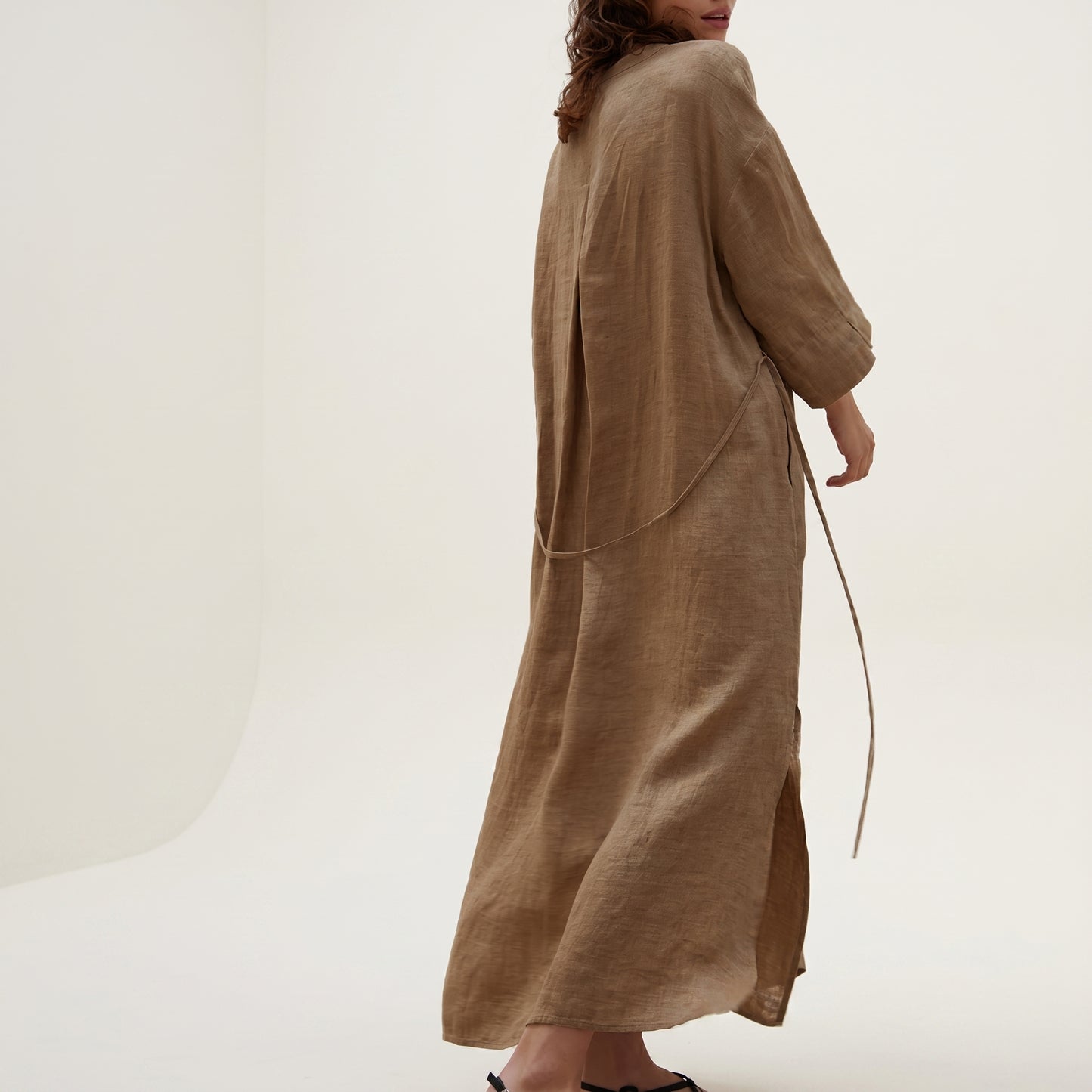 Brown long dress worn by a person on a white background