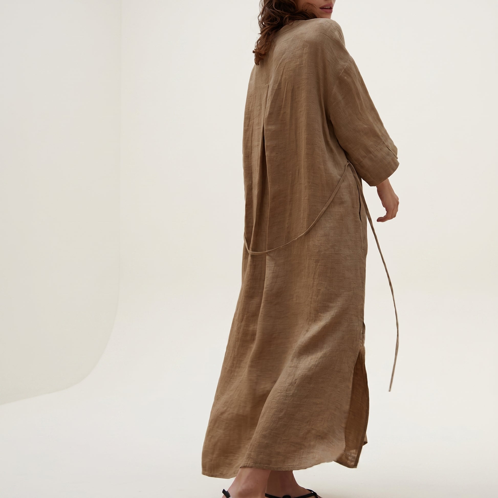 Brown long dress worn by a person on a white background