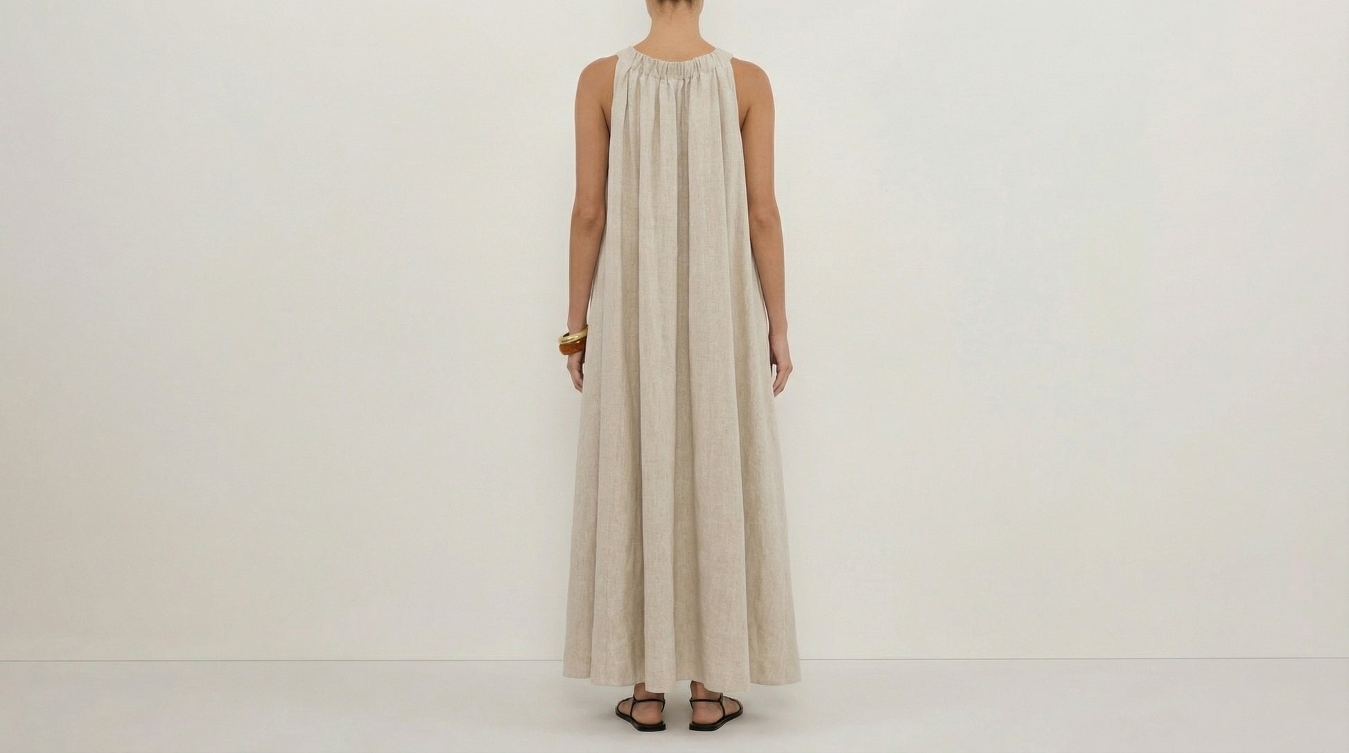 Person wearing a long beige dress on a white background