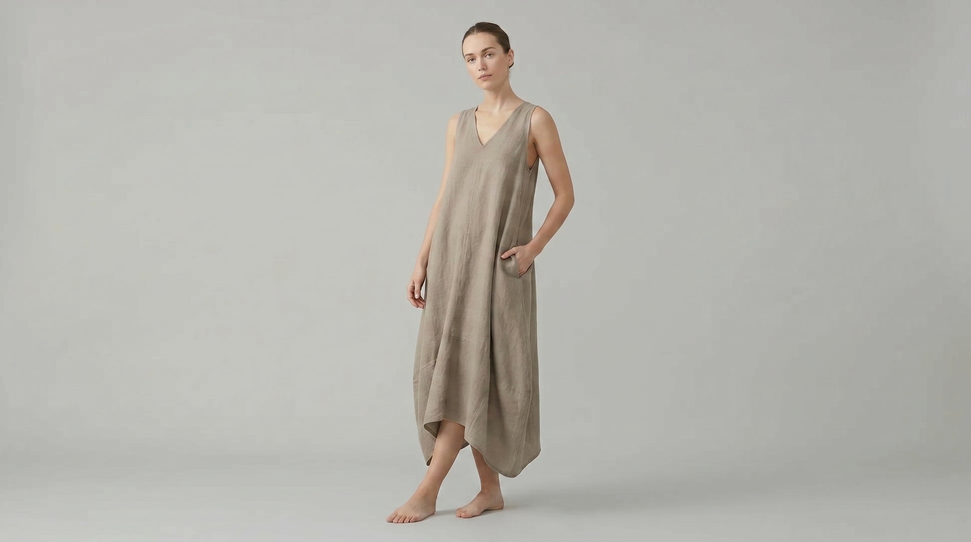 Woman wearing a beige dress against a plain background