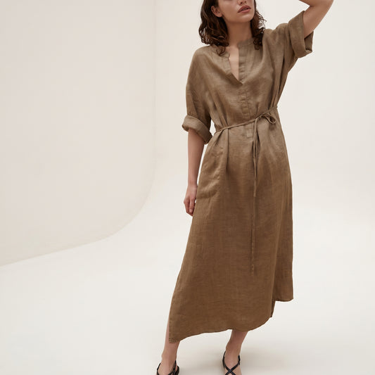 Woman wearing a brown dress against a white background