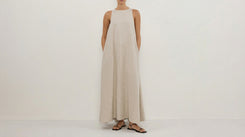 Woman wearing a long beige dress on a white background