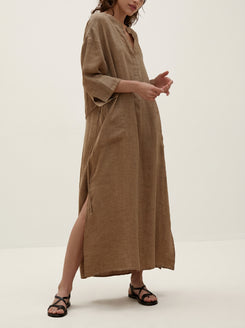 Woman wearing a long brown dress on a white background
